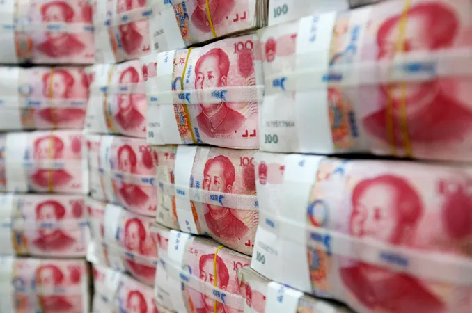 Inside Story - File photograph of Chinese yuan notes piled up after counting at a bank during a photo opportunity in Seoul