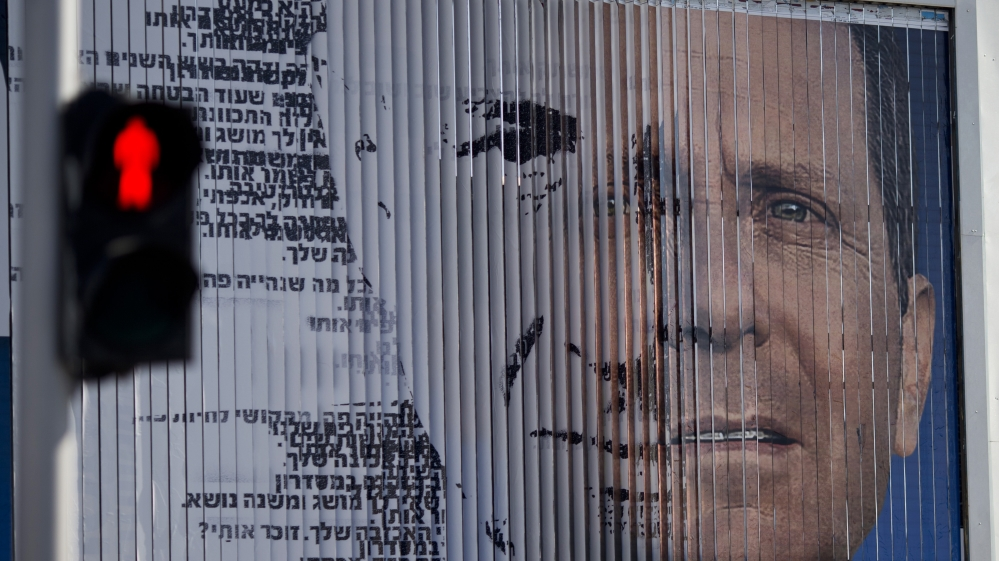 An election campaign billboard shifts between images of Herzog and Netanyahu [AP]