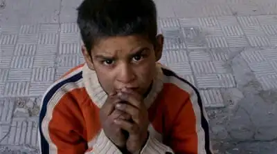 A child sitting on a broken pavement after hearing that Syrian authorities would allow civilians to leave the Palestinian neighborhood of Yarmouk in Damascus [AP]
