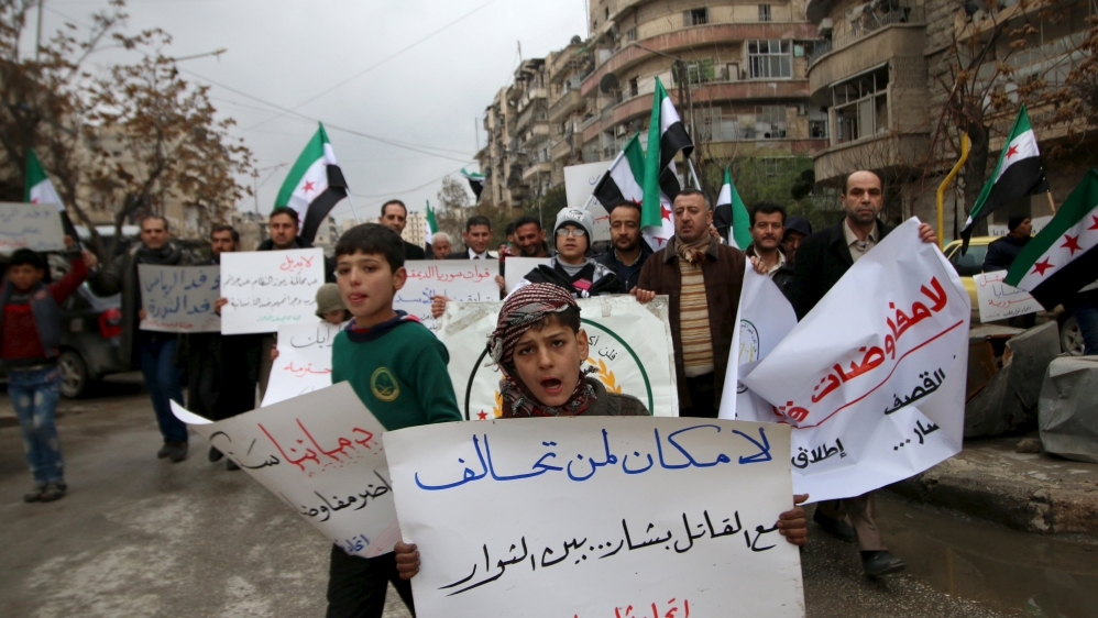 Residents carry banners and opposition flags as they march during a protest in Aleppo, asking for the release of prisoners held in government jails, in al-Fardous neighbourhood of Aleppo