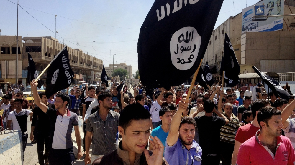 Demonstrators chant pro-ISIL slogans as they carry the group''s flags in front of the provincial government headquarters in Mosul [AP]