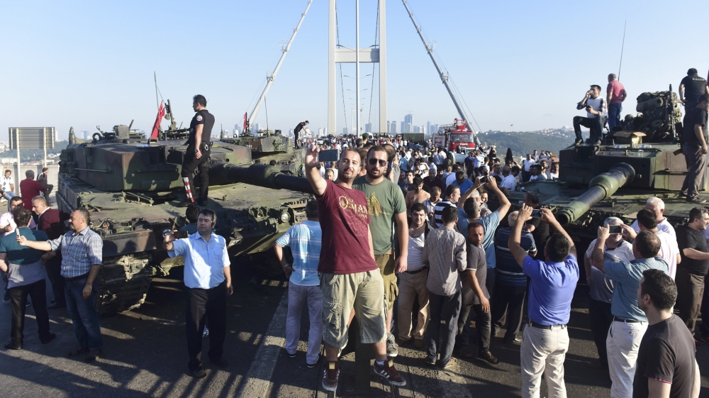 People take selfies after soldiers involved in the coup surrendered on the Bosphorus Bridge in Istanbul