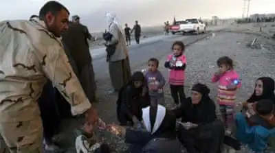 People rest as they flee their homes during clashes between Iraqi security forces and ISIL in Mosul, Iraq [AP]
