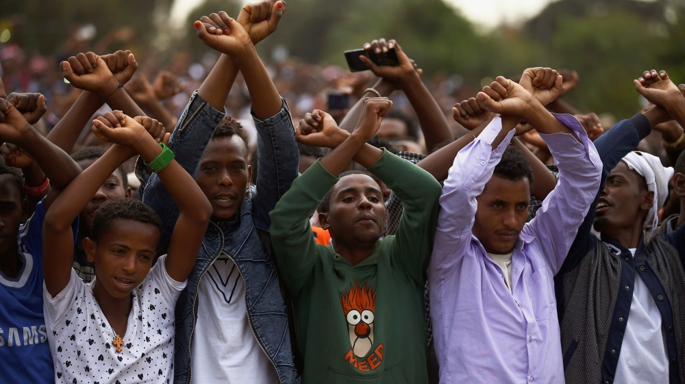 Demonstrators chant slogans while flashing the Oromo protest gesture during Irreecha, the thanksgiving festival of the Oromo people, in Bishoftu town, Oromia region, Ethiopia