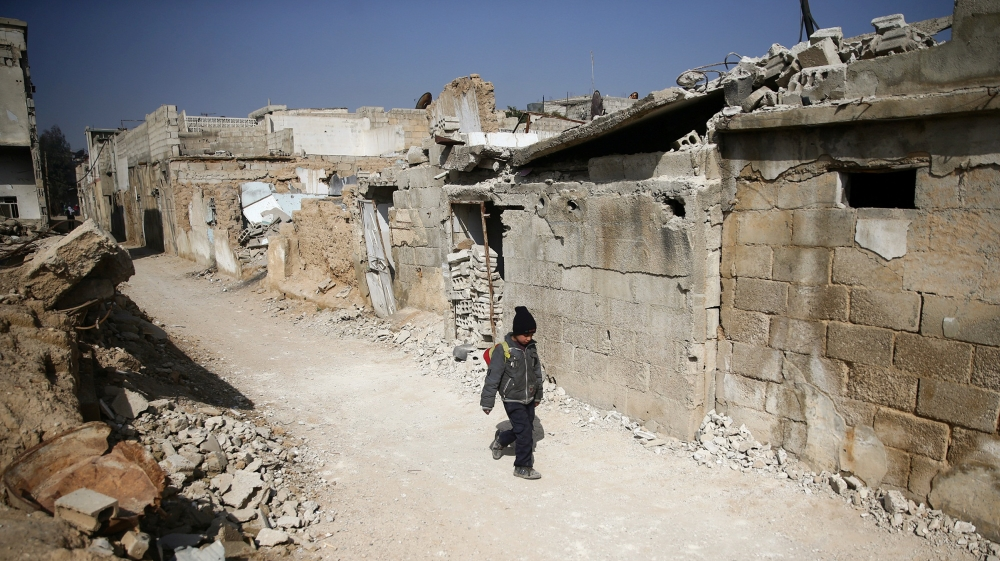 A boy walks along a street in the rebel held besieged Douma neighbourhood of Damascus