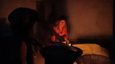Cai Fengxia's adoptive father cooks for her in Dangshan, eastern China [Han Meng/Al Jazeera]
