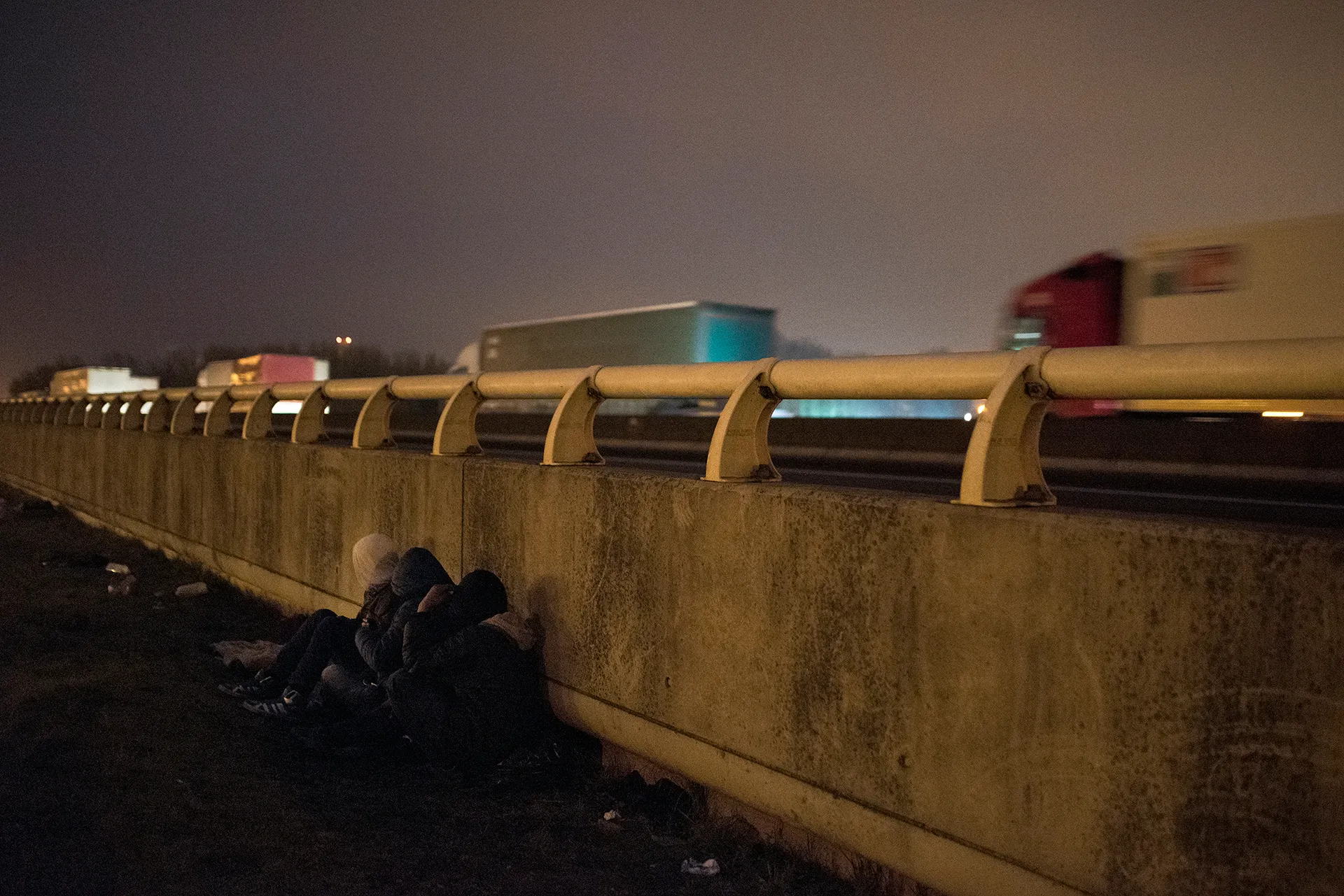Young Eritrean and Oromo Ethiopian refugees wait next to a motorway close to a truck stop [Guillem Trius/Al Jazeera]