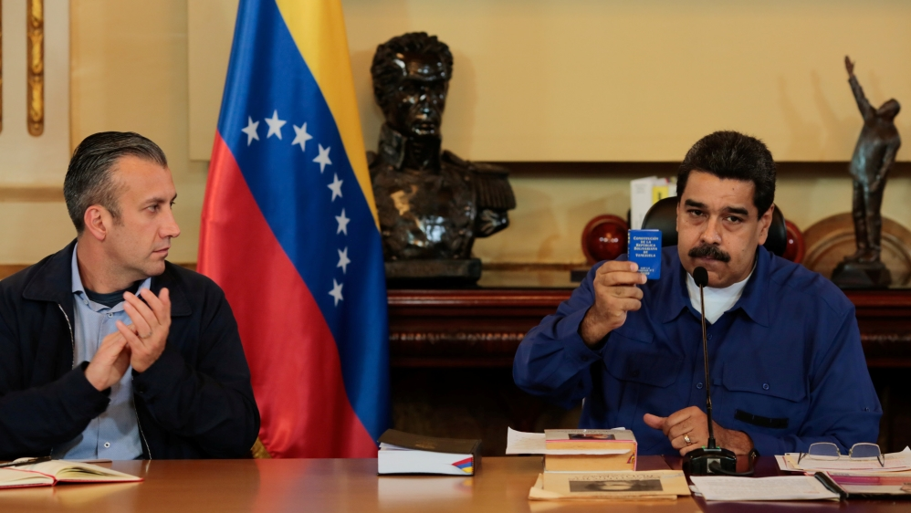 Venezuela''s President Nicolas Maduro shows a copy of the country''s constitution as he sits next to Vice President Tareck El Aissami, during a meeting with Vice Presidents