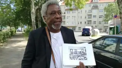 
Tanzanian-born campaigner Mnyaka Sururu Mboro recalls the personal stories of how the German empire affected his family [Gouri Sharma/Al Jazeera] 