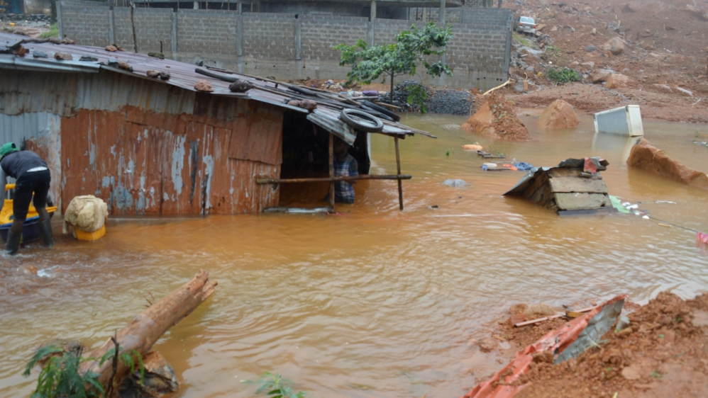 Residents save belongings in floodwaters after a mudslide in the mountain town of Regent