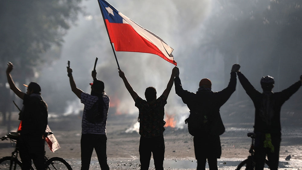 A demonstrator holds a Chilean flag during a protest against inequality in Santiago