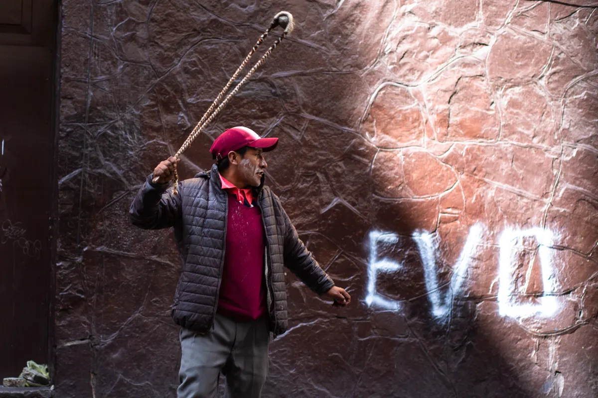 A supporter of ousted president Evo Morales throws rocks at the police after tearing down a barricade during demonstrations in support of the ousted president Evo Morales La Paz, Bolivia. Nov. 15, 201