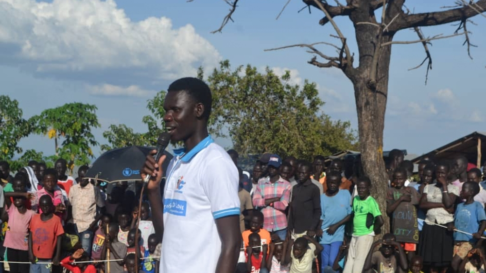 I CAN South Sudan personnel addressing a crowd during a Peace Concert in Bidi Bidi camp