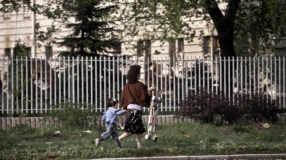 A mother and child run for their lives along Sniper Alley to avoid being hit by Serb sniper fire in Sarajevo in 1995