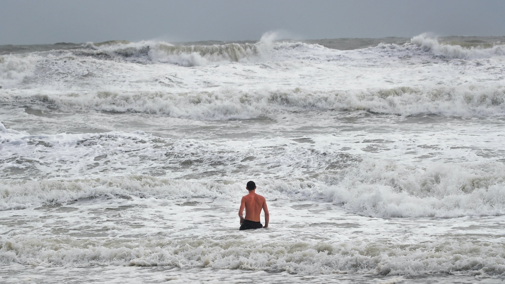 A swimmer explores the waves during high tide as Hurricane Dorian churns offshore on September 3, 2019 in Indialantic, Florida