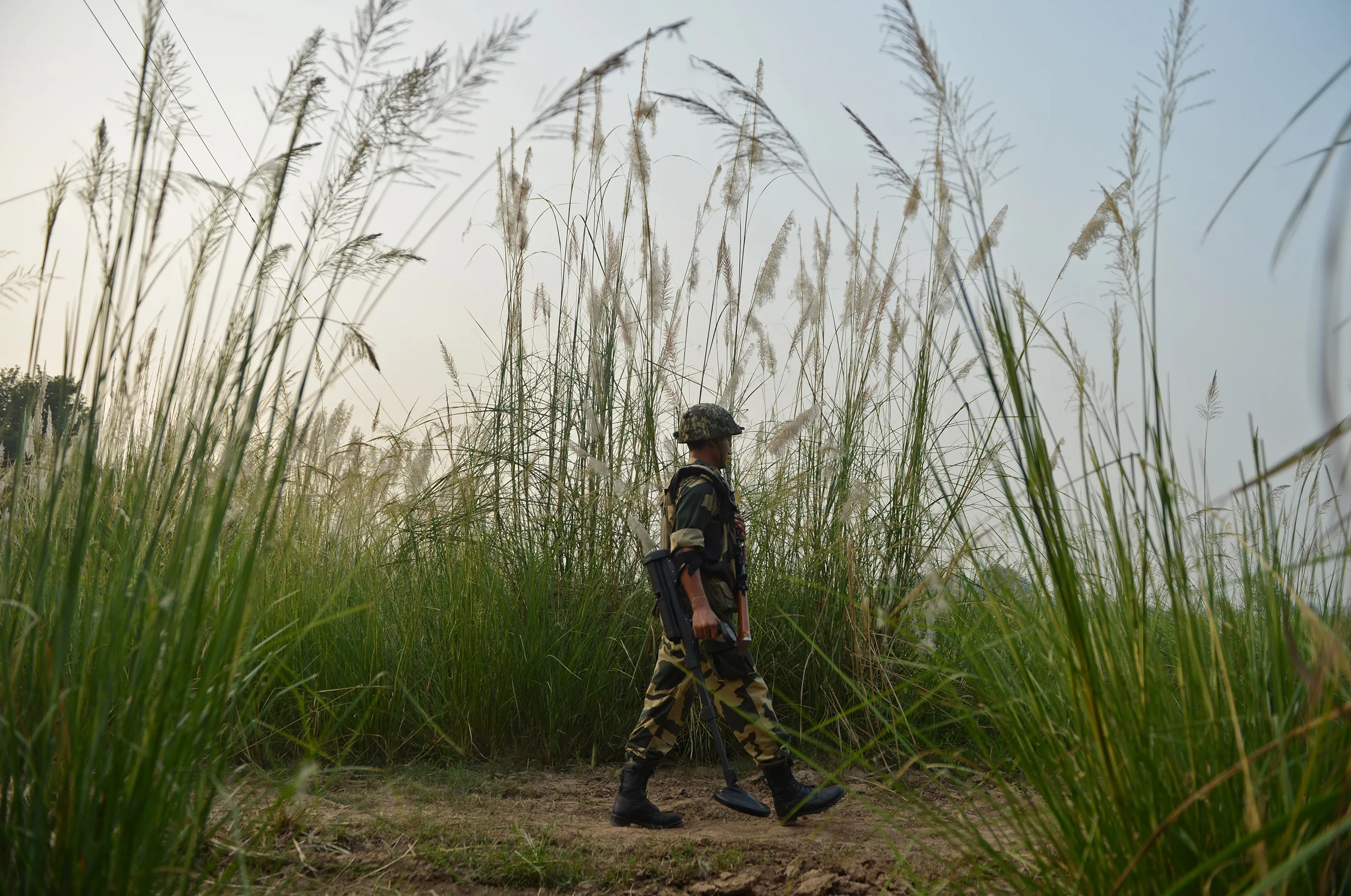 An Indian border security force soldier searches for landmines with a metal detector during a patrol at the India-Pakistan border in RS Pora, southwest of Jammu, in October 2016